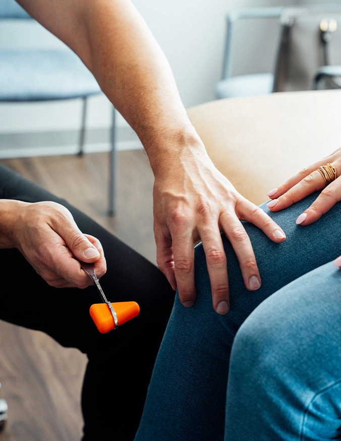 Physical therapist examining patient's knee during rehabilitation session in clinical setting - Thoracic Stenosis in Carmel, IN